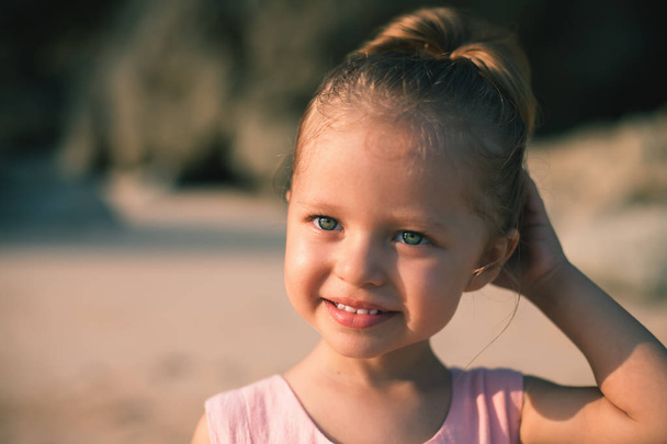 Όμορφο μικρό κορίτσι στην παραλία. Αντιηλιακή Κρέμα για παιδιά. - Φωτογραφία, εικόνα