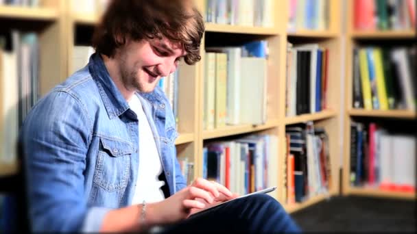 Student nutzt moderne IT-Technologie in Bibliothek - Filmmaterial, Video