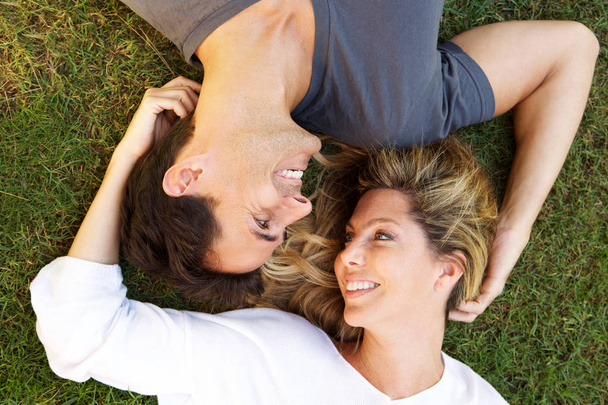 Close up ritratto di coppia spensierata sdraiati sull'erba insieme in amore - Foto, immagini