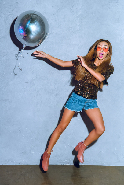 surprised stylish african american girl with shiny balloon looking at camera - Foto, Imagen