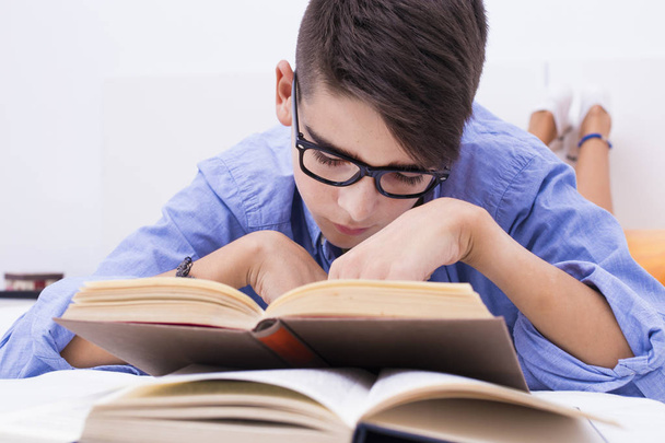 criança pré-adolescente estudando com livros na sala de casa
 - Foto, Imagem