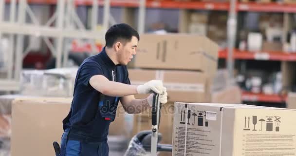 Trabajador empujando carro con cajas en almacén
 - Metraje, vídeo