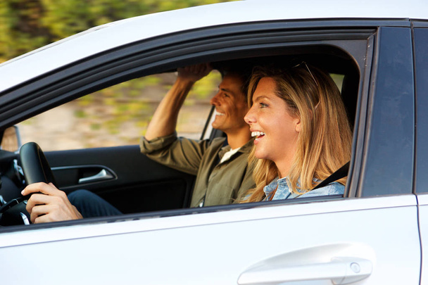 Primer plano retrato de lado de pareja atractiva riendo en coche en viaje por carretera
 - Foto, imagen