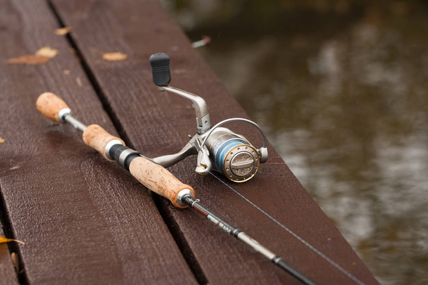 Fishing Rod On Wooden Pier On Pond On Fishing Outdoor Close Up. - Photo, image
