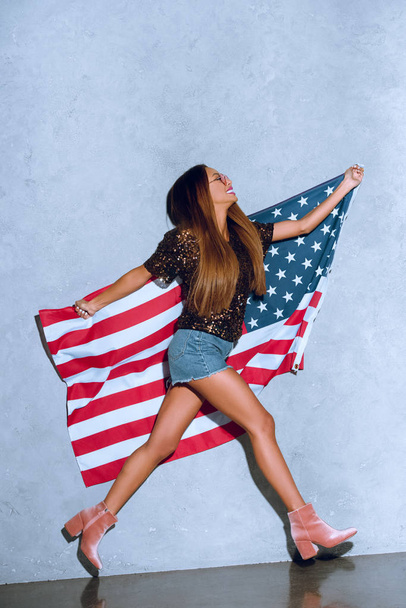 mujer afroamericana feliz con bandera americana en las manos
 - Foto, Imagen