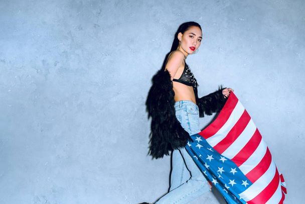 retrato de bela mulher asiática com bandeira americana contra parede de concreto
 - Foto, Imagem