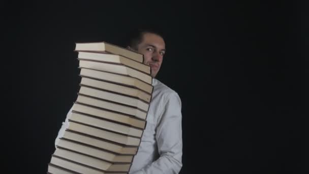 Ein junger Mann nimmt einen Stapel Bücher in die Hand. Geschäftsmann mit Büchern in der Hand. - Filmmaterial, Video