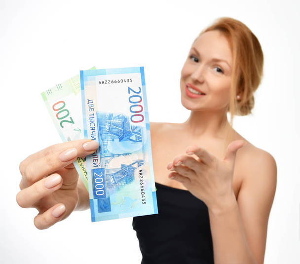 Young woman holding up cash money two thousand and hundred russian rubles notes in hand winner surprised  - Fotó, kép