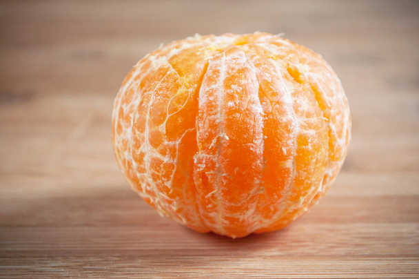  peeled tangerine on wooden cutting board background - Foto, Bild