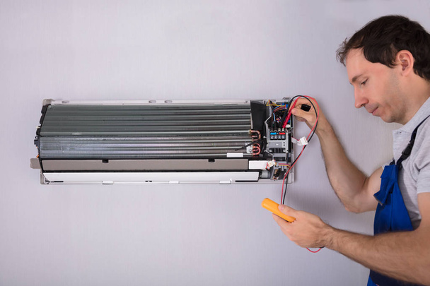 Male Technician Testing Air Conditioner With Digital Multimeter - Fotografie, Obrázek