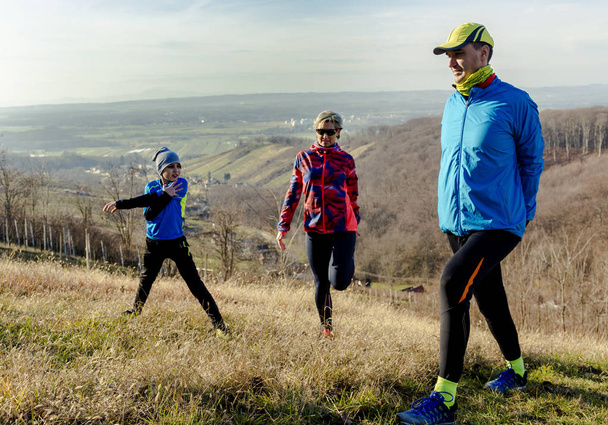 Family jogging for sport outdoors with the kids on sunny winter day. - Photo, Image