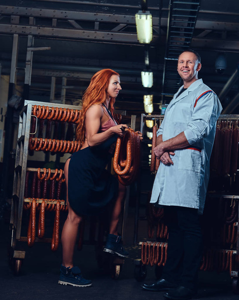 Portrait d'un chef et de son assistante dans un entrepôt de saucisses
. - Photo, image