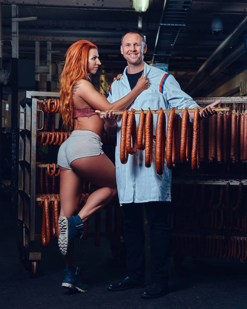 Retrato de um chef e sua ajudante feminina em um armazém de salsichas
. - Foto, Imagem