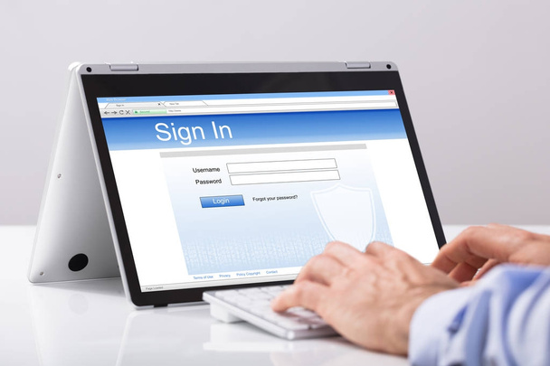 Zbliżenie: biznesmen za pomocą cyfrowego tabletu do podpisywania nad biały biurko w miejscu pracy - Zdjęcie, obraz