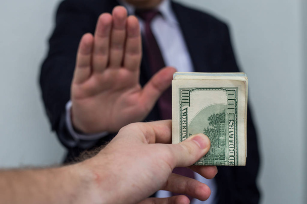 Suborno e corrupção, ofereceu dinheiro para um homem de negócios em um terno, d
 - Foto, Imagem