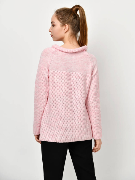 Young beautiful woman posing in new casual pink sweater - 写真・画像