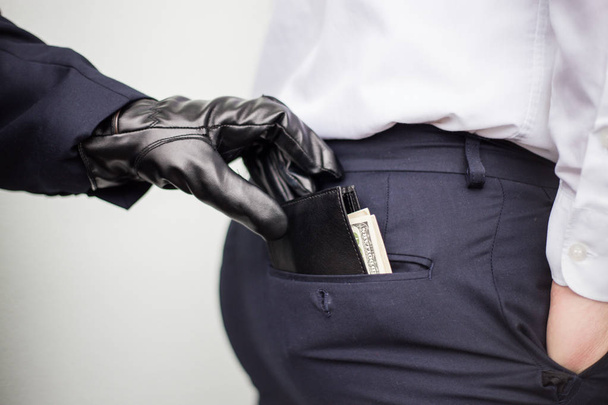 Ένας κλέφτης λαμβάνει ένα πορτοφόλι με ένα χρήμα από την τσέπη ενός άνδρα σε ένα s - Φωτογραφία, εικόνα
