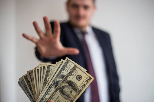 Soborno y corrupción, ofreció dinero en efectivo a un hombre en un traje, que toma
  - Foto, Imagen