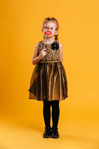 Pretty little girl child holding fake lips. - Valokuva, kuva