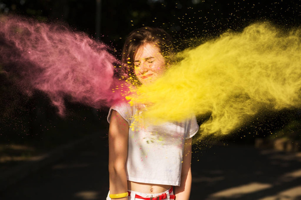 Linda morena modelo se divertindo em uma nuvem de amarelo e rosa d
 - Foto, Imagem