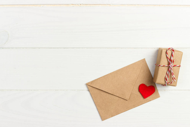 Valentine con il cuore rosso. Un pacco di carta legato. Un cuore rosso con confezione regalo avvolta con carta kraft
 - Foto, immagini