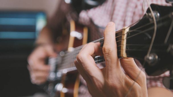 Male musician plays the guitar, hands close up, focus on the guitar fretboard - Photo, Image