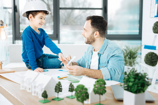 Smiling architect asking his son to choose a color - Photo, image