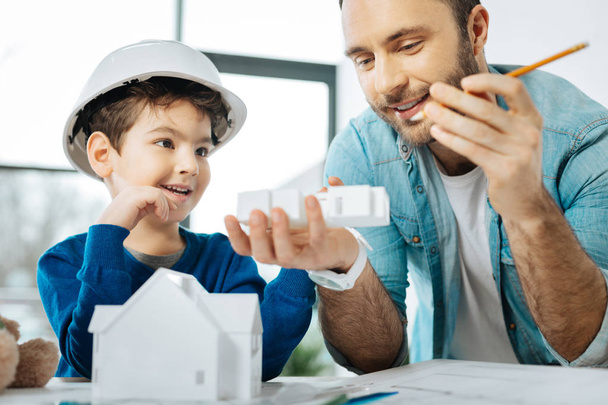 Cheerful father and son looking at results of 3D printing - 写真・画像