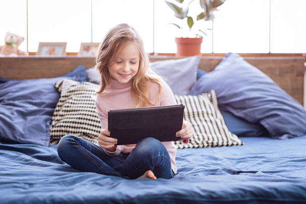 Content girl playing games on her tablet - Photo, image
