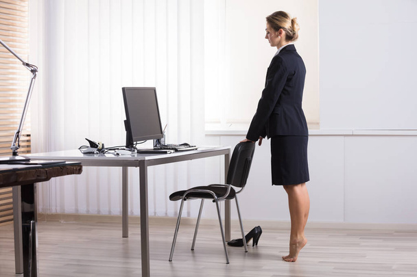 Young Businesswoman Stretching Her Legs At Workplace - Photo, Image