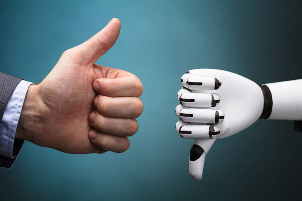Businessperson And Robot Showing Thumb Up And Thumb Down Sign On Turquoise Background - 写真・画像