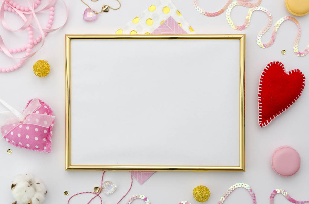 Golden Photo frame make up with space for text or photo and romantic accessories on white background. Квартира лежала, вид сверху. Любовный фон сердца
. - Фото, изображение