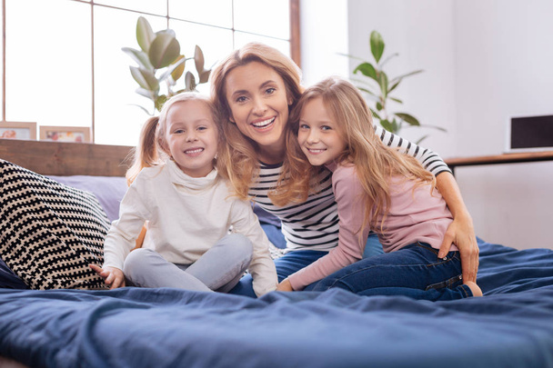 Happy mother and her daughters cuddling - Foto, afbeelding