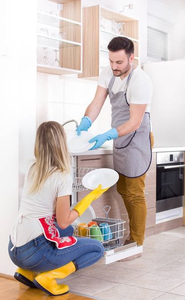 幸せなカップルのアンロード食器洗い機 - 写真・画像