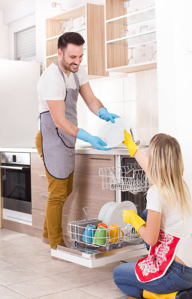 Ευτυχισμένο ζευγάρι εκφόρτωσης πλυντήριο πιάτων - Φωτογραφία, εικόνα
