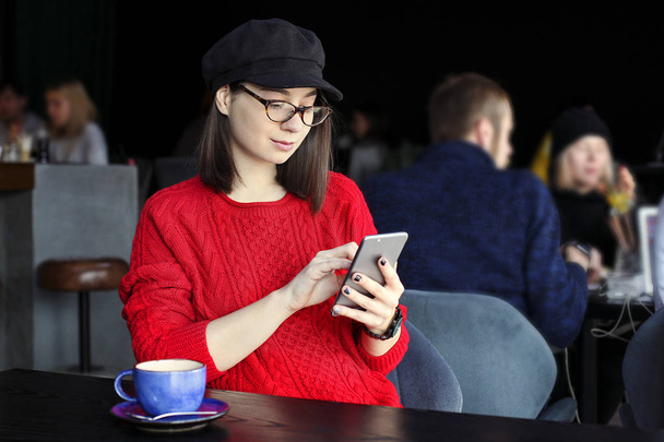Ευτυχισμένη γυναίκα πίνοντας καπουτσίνο, latte, macchiato, τσάι, χρησιμοποιώντας τον υπολογιστή tablet και μιλάμε στο τηλέφωνο σε ένα κατάστημα καφέ / μπαρ. - Φωτογραφία, εικόνα