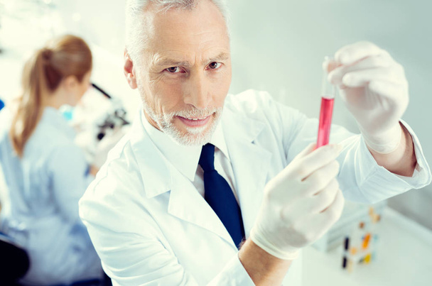 Mature scientist posing with test tube in lab - Photo, Image
