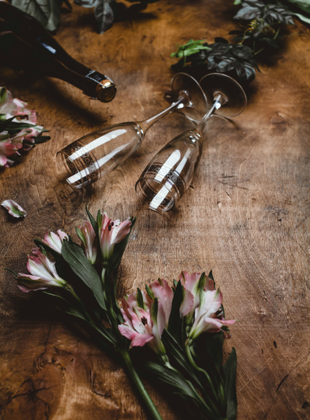 квіти, пляшка шампанського і окуляри на дерев'яні таблиці - Фото, зображення
