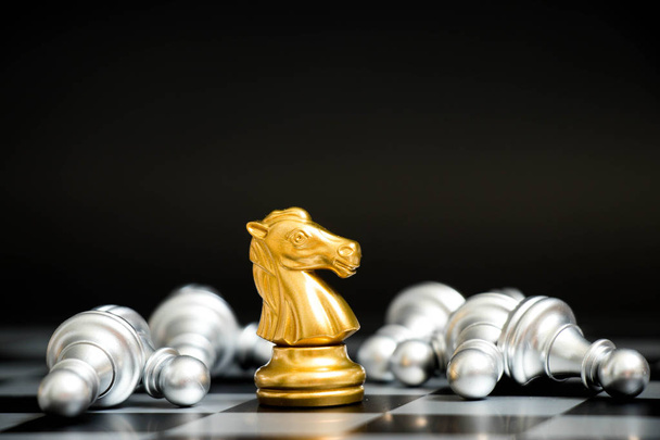 Goldpferd im Schachspiel Gesicht mit einem weiteren silbernen Team auf schwarzem Hintergrund (Konzept für Unternehmensstrategie, Geschäftssieg oder Entscheidung)) - Foto, Bild