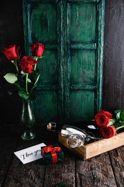 te amo tarjeta de felicitación, regalo, rosas rojas y botella de champán con copas para el día de San Valentín
 - Foto, Imagen