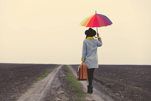 jeune femme avec parapluie et valise
  - Photo, image