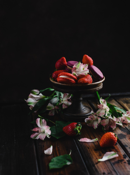 tazón con macarrones y fresas sobre mesa de madera con flores
 - Foto, Imagen