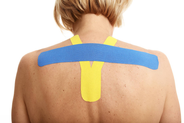 Picture showing special physio tape put on injured back over white background - Фото, зображення