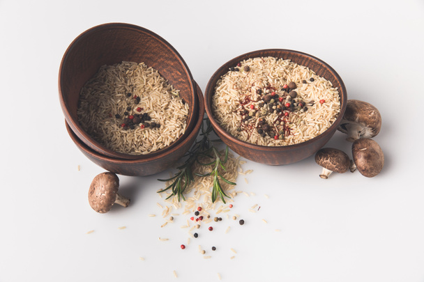 bowls of raw rice with spices and mushrooms on white tabletop - Photo, Image