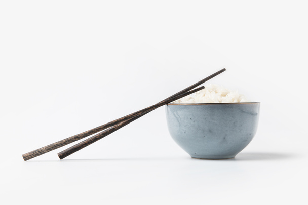 bowl of tasty rice with chopsticks on white tabletop - Photo, Image