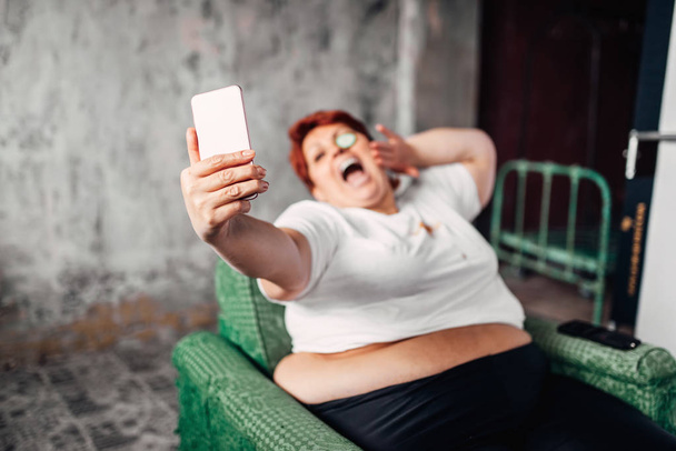 overweight woman taking selfie, laziness and obesity, unhealthy lifestyle concept - Foto, Imagen