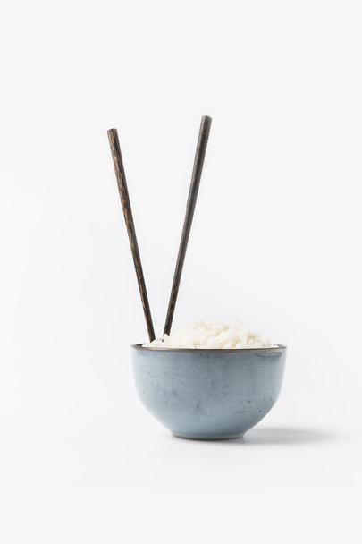 bowl of freshly cooked rice with chopsticks on white surface - Fotó, kép