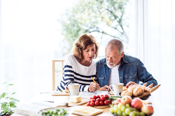 Senior couple eating breakfast at home. - Foto, Imagen