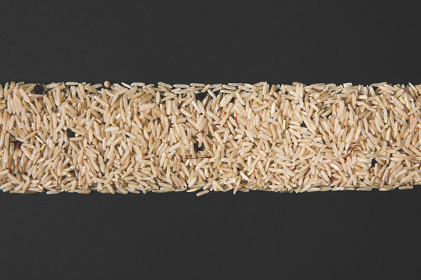 top view of stripe of raw rice isolated on black - Photo, Image