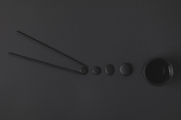 composición plana creativa de palillo con taza de té chino y guijarros en negro
 - Foto, imagen